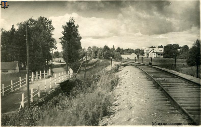 Ж.-д. путь в Кякисалми. Фотооткрытка Талвенгеймо, конец 1920-х гг. (скорее всего).
Фотография сделана на южном подходе к станции. Справа от ж.д. пути заметен ряд столбиков, на которых укреплены ролики тросов управления входным семафором.
(с) Из коллекции С. Ренни sr_Kakisalmi-02.jpg